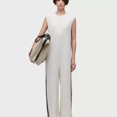 Macacão branco com riscas pretas e mala bege com alças pretas