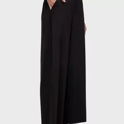 Calças pretas largas com bolso lateral em tecido liso