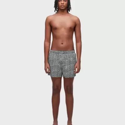 Calção de banho preto e branco com padrão geométrico usado por modelo