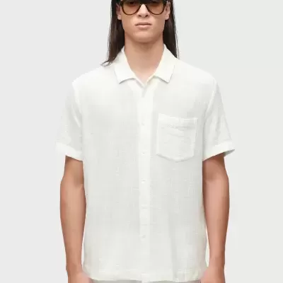 Homem com camisa branca de manga curta, colarinho e bolso no peito