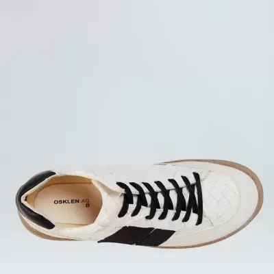 Ténis branco com detalhes pretos e sola castanha vistos de cima