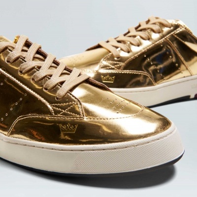 Ténis dourados metálicos com atacadores bege e sola branca espessa