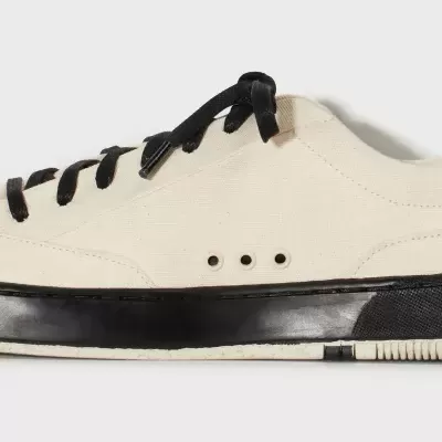 Ténis cor creme com atacadores pretos e sola preta e creme