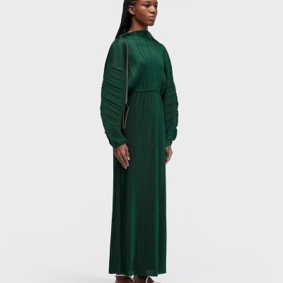 Vestido comprido verde escuro com pregas verticais e sapatos rasos brancos
