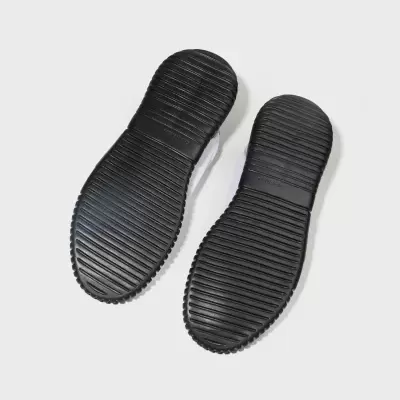 Sola preta de sapatilhas com ranhuras horizontais e logo OSKLEN