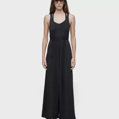 Macacão preto feminino de alças largas com cinto fino e calças largas.