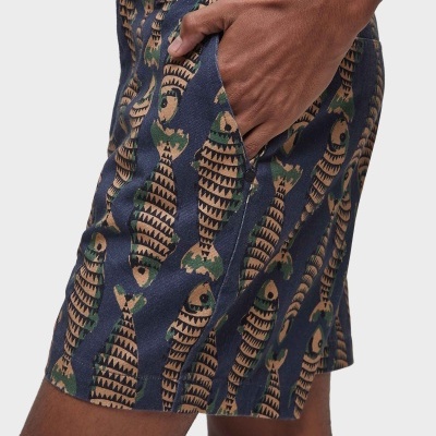 Calções azuis com padrão de peixes castanhos e verdes e bolso lateral