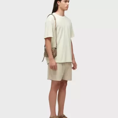 Pessoa com roupa casual clara e bolsa trançada