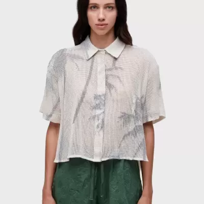 Camisa feminina branca transparente com padrão de folhagem cinzenta e calções verdes texturizados