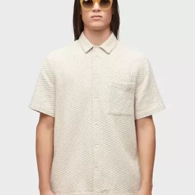 Camisa bege de manga curta com textura em relevo e bolso no peito