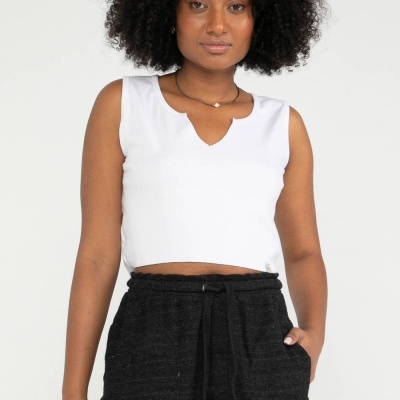 Mulher a usar top branco sem mangas e saia preta com cordão