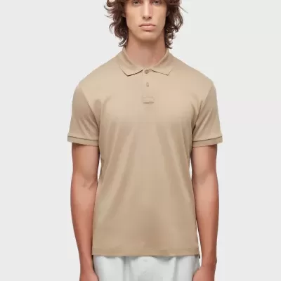 Homem a vestir polo bege de algodão e calções brancos