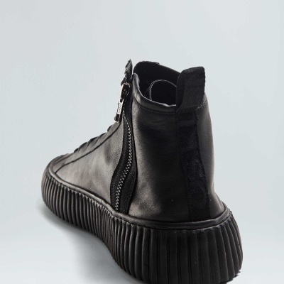 Bota preta de couro com sola grossa e fecho lateral