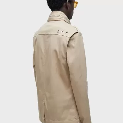 Casaco bege visto de costas com gola alta e ilhóses no ombro