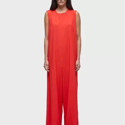 Mulher com macacão largo vermelho sem mangas e óculos de sol pretos