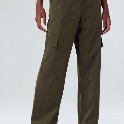 Calças cargo verde-oliva com bolsos laterais e sapatos brancos com detalhes azuis