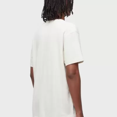 Pessoa de costas a usar t-shirt branca de manga curta e calças de ganga azuis claras