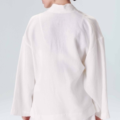 Blusa branca de manga comprida com calções brancos vista de costas