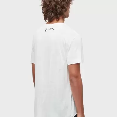 Camiseta branca com símbolo e estrelas pretas nas costas, usada com calções pretos por modelo masculino visto de costas