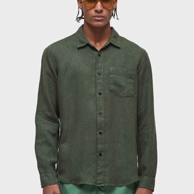 Camisa verde escura de manga comprida com bolso no peito usada por homem com óculos de sol