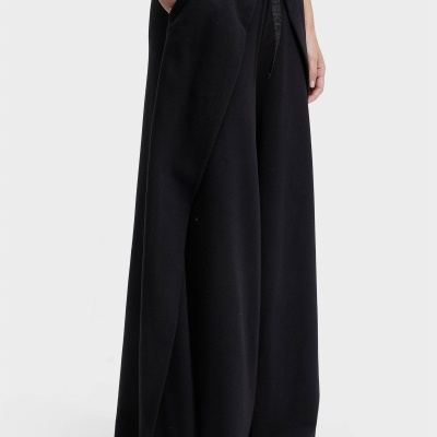 Calça preta larga com bolsos e cordão, sandália castanha, t-shirt verde claro