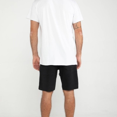 Homem visto de costas com t-shirt branca, shorts pretos e ténis pretos VERT