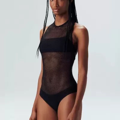 Body de rede preto com decote alto usado por modelo feminina em fundo cinza claro