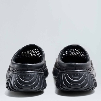 Par de calçado mule preto com sola grossa, visto de trás