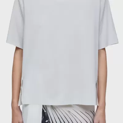 Blusa branca de manga curta com decote redondo, combinada com saia branca com padrão gráfico preto