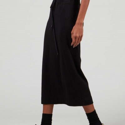 Saia preta comprida até à canela com ténis pretos e meia preta