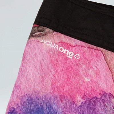 Pano com padrão colorido em rosa, roxo e azul e dobra preta com texto AQUAone