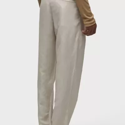 Calças bege retas com bolso traseiro, camisa castanha e sapatos de couro trançado