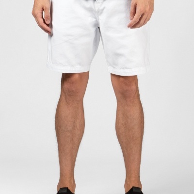 Bermuda branca masculina com camiseta preta e calçado preto em fundo cinzento claro.