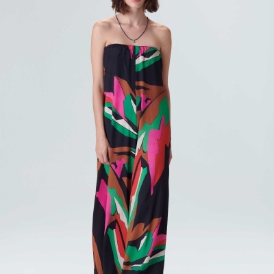 Vestido comprido colorido com padrão abstrato em mulher com chapéu de palha