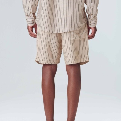 Calções bege com riscas verticais usados por pessoa de costas