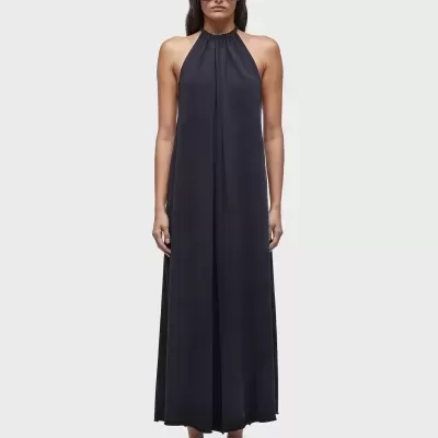 Vestido longo preto com gola alta e sandálias pretas.