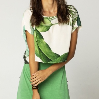 Camiseta branca com estampa de folhas verdes e saia verde