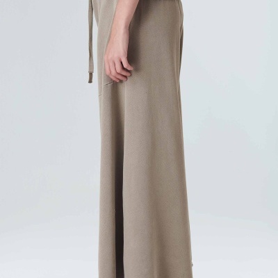 Calças de malha bege claro com cordão de ajuste e ténis brancos com padrão xadrez preto