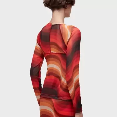 Top e saia estampados em tons vermelhos e laranja vistos de costas