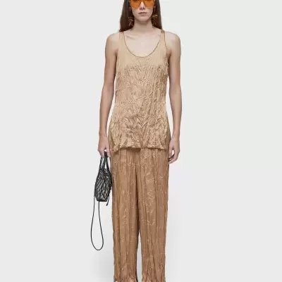 Conjunto bege enrugado, óculos amarelos, bolsa preta rede