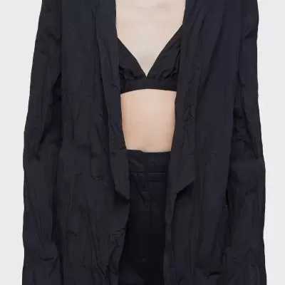 Conjunto feminino com blazer preto, sutiã e calças pretas num fundo branco