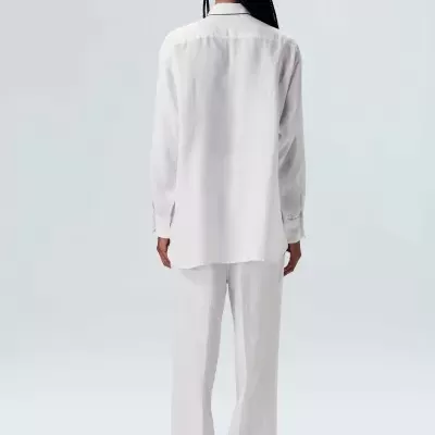 Conjunto branco com camisa e calças largas visto de costas