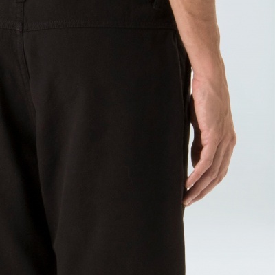 Calções pretos simples vistos de costas num fundo neutro