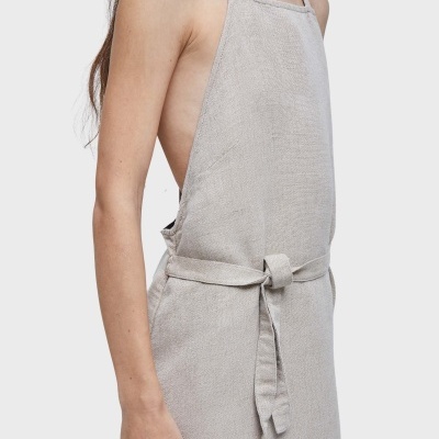 Pessoa de perfil com avental cinza claro texturizado