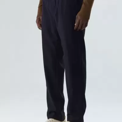 calças azuis escuras com cós elástico e tênis brancos