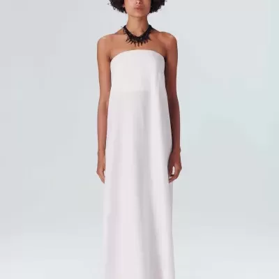 Mulher com vestido longo branco sem alças em fundo claro