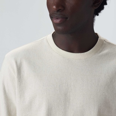 Homem com camisola creme de malha com gola redonda