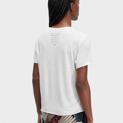 Pessoa de costas com camiseta branca e saia com padrão colorido abstrato