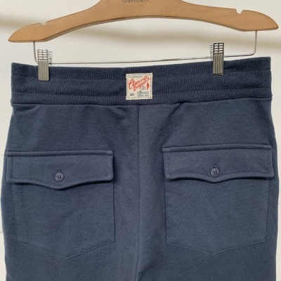 Calças azul escuro com bolsos, etiqueta Original e cabide OSKLEN