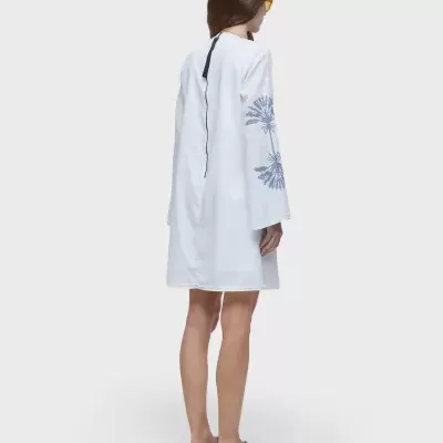 Vestido branco com estampado azul nas mangas, visto de costas.